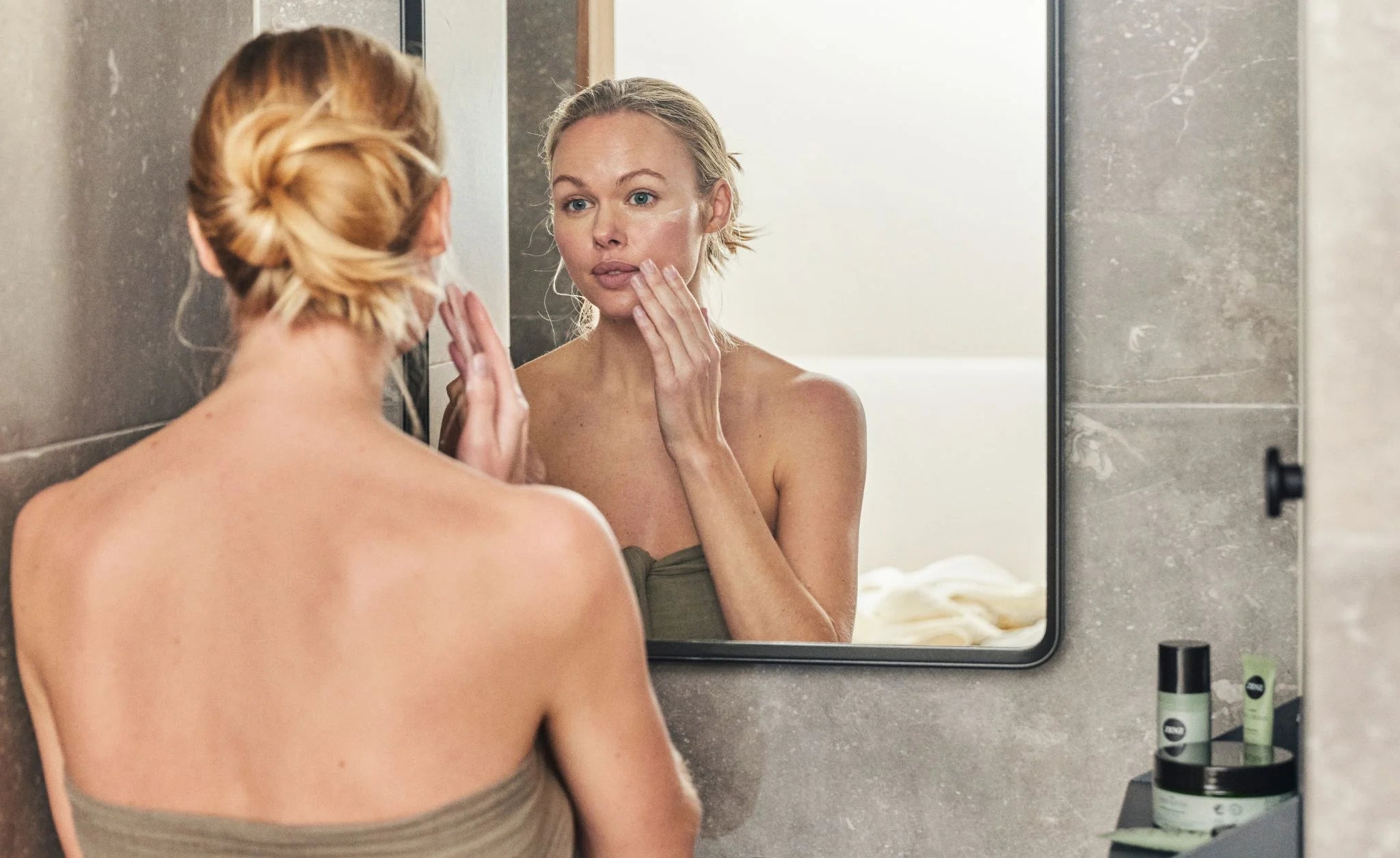 Kvinde bruger ZENZ Natural Skincare i sin hudplejerutine og påfører produkterne i den rigtige rækkefølge for at pleje og beskytte huden bedst muligt.